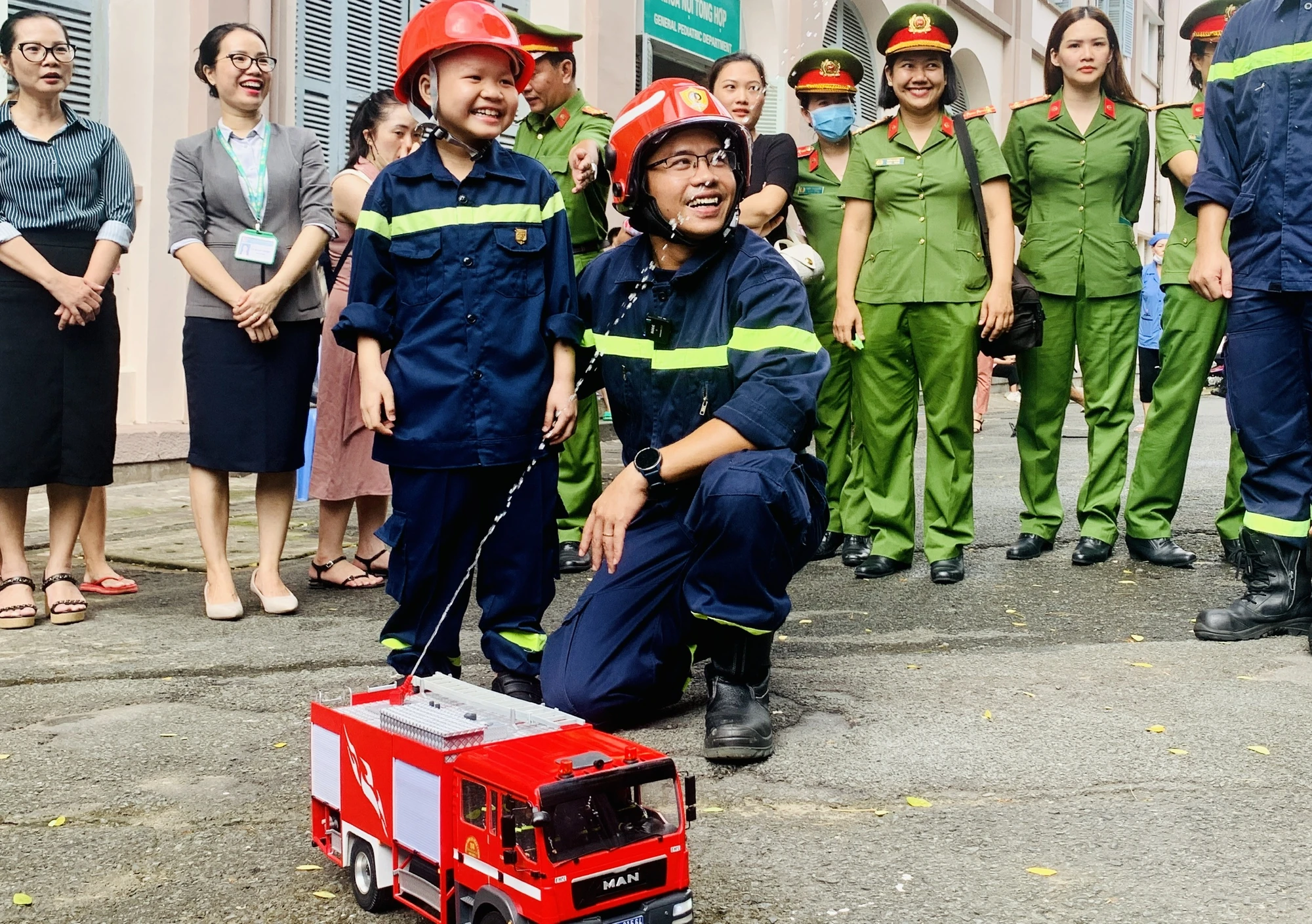 Nụ cười trên môi cậu bé khi được trải nghiệm công việc của lính cứu hỏa. Ảnh: THẢO PHƯƠNG Nụ cười trên môi cậu bé khi được trải nghiệm công việc của lính cứu hỏa. Ảnh: THẢO PHƯƠNG