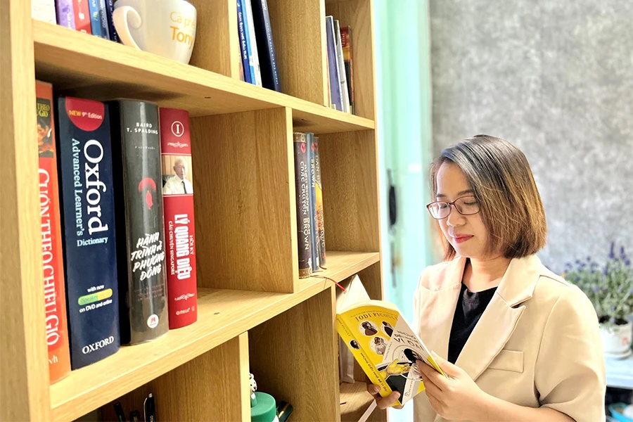 Tác giả bên kệ sách tự tay lắp ghép trong căn nhà trọ của mình. Ảnh: NVCC Tác giả bên kệ sách tự tay lắp ghép trong căn nhà trọ của mình. Ảnh: NVCC
