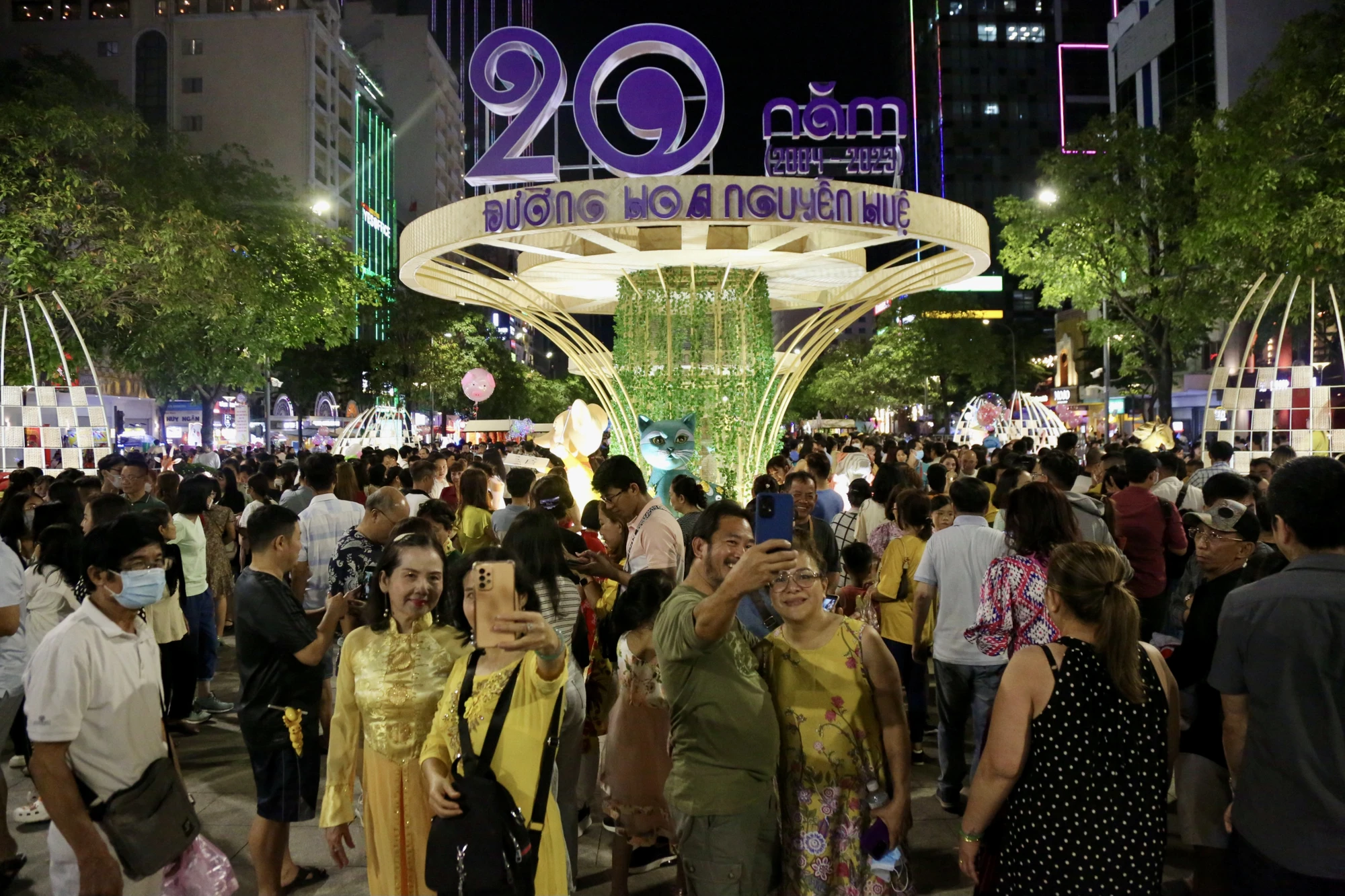 Sau lưng cổng chào đường hoa 2023 nhiều người hào hứng check-in với 20 linh vật trong hai thập kỷ. Ảnh: BẢO PHƯƠNG Sau lưng cổng chào đường hoa 2023 nhiều người hào hứng check-in với 20 linh vật trong hai thập kỷ. Ảnh: BẢO PHƯƠNG