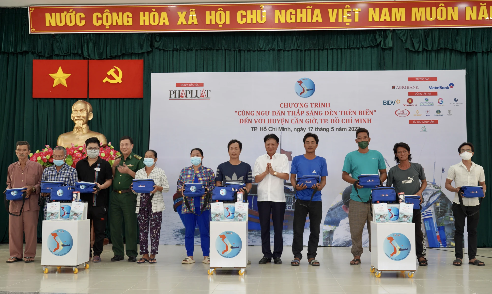 Ông Phạm Trung Kiên, Phó Trưởng Văn phòng đại diện Agribank miền Nam và Đại tá Nguyễn Đức Phong, Phó Trưởng phòng Dân vận, Cục chính trị Bộ Tư lệnh Bộ đội biên phòng trao các phần quà cho gia đình các hộ ngư dân. Ảnh: MINH HOÀNG