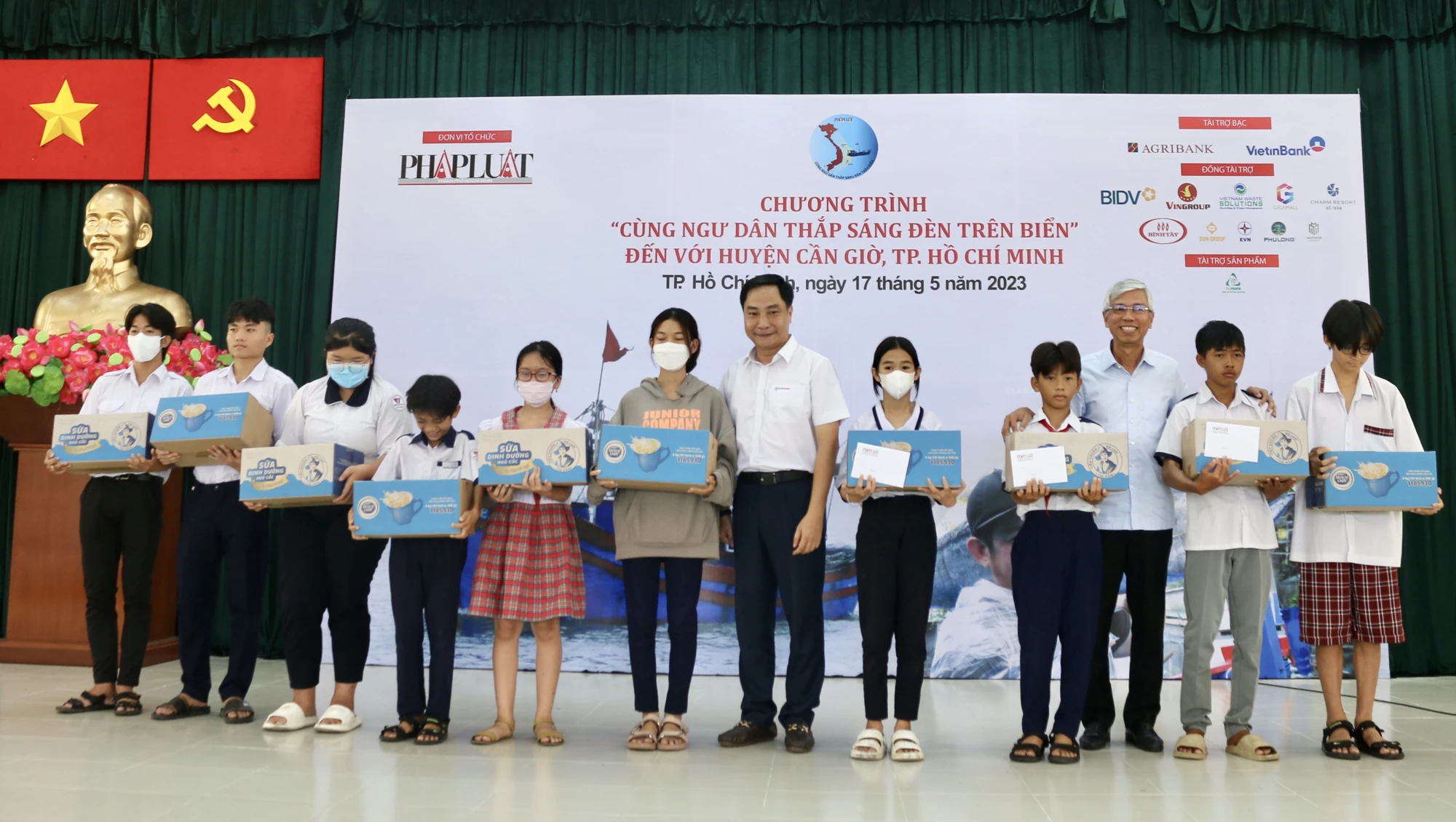 Phó Chủ tịch UBND TP.HCM Võ Văn Hoan và ông Nguyễn Thanh Nhã, Phó Tổng giám đốc Tổng Công ty điện lực TP.HCMtrao học bổng cho con em của bà con ngư dân có hoàn cảnh khó khăn của huyện Cần Giờ. Mỗi phần học bổng trị giá trên 3 triệu đồng. Ảnh: THIỆN HỢP