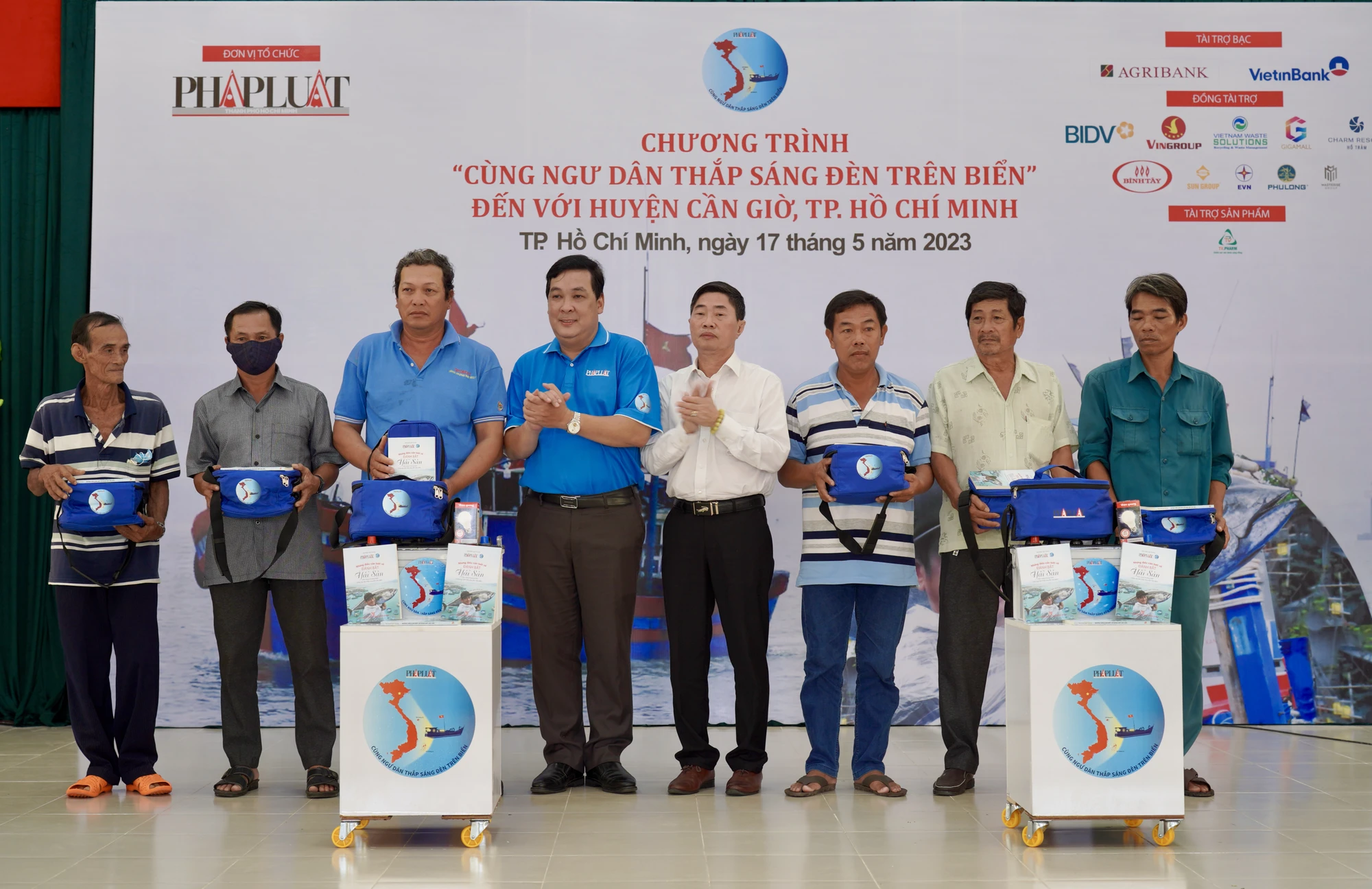 Ông Nguyễn Thái Bình, Phó Tổng biên tập Báo Pháp Luật TP.HCM và ông Lê Thanh Chiến, Phó Trưởng văn phòng đại diện Bộ NN&amp;PTNT tại TP.HCM trao các phần quà cho gia đình các hộ ngư dân ở Cần Giờ. Ảnh: MINH HOÀNG