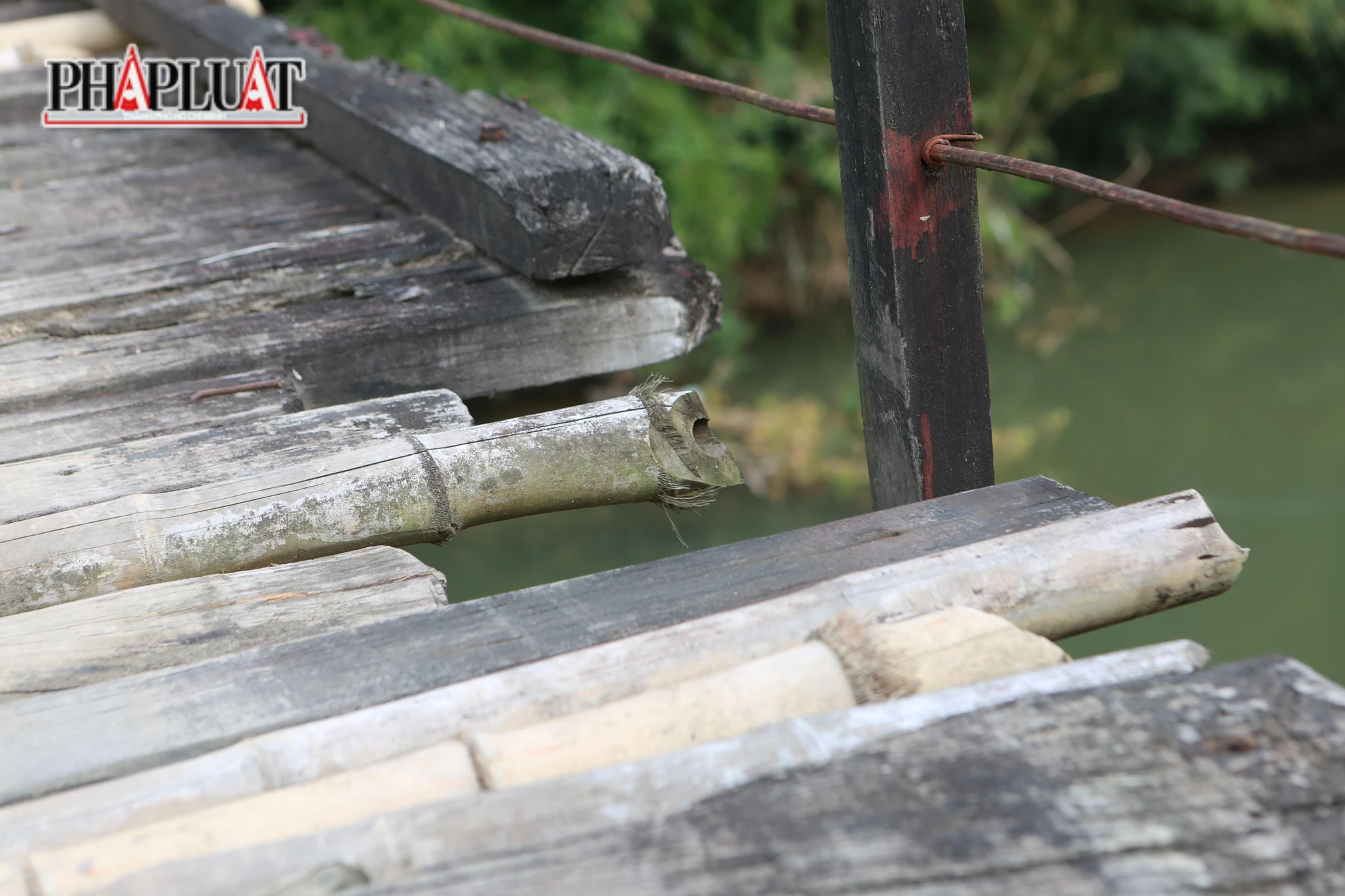 Nhiều đoạn ván mục nát rơi xuống sông . Nhiều đoạn ván mục nát rơi xuống sông .