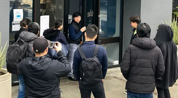 Nhân viên ngân hàng Silicon Valley (trung tâm) nói chuyện với những người đứng bên ngoài chi nhánh ngân hàng này ở TP Santa Clara, bang California (Mỹ) hôm 10-3. Ảnh: AP