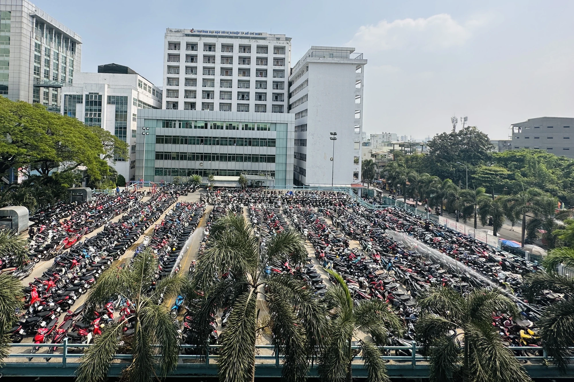 Đều đặn mỗi ngày từ khoảng 13 giờ đến 14 giờ, nhân viên trường Đại học Công nghiệp TP.HCM sẽ dùng vòi phun nước từ hệ thống phòng cháy PCCC để làm mát bãi xe máy sinh viên. Ảnh: HT Đều đặn mỗi ngày từ khoảng 13 giờ đến 14 giờ, nhân viên trường Đại học Công nghiệp TP.HCM sẽ dùng vòi phun nước từ hệ thống phòng cháy PCCC để làm mát bãi xe máy sinh viên. Ảnh: HT