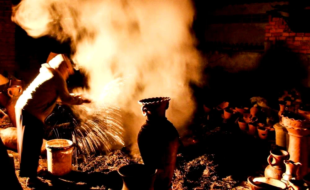 Người thợ phun nước tạo màu cho gốm.