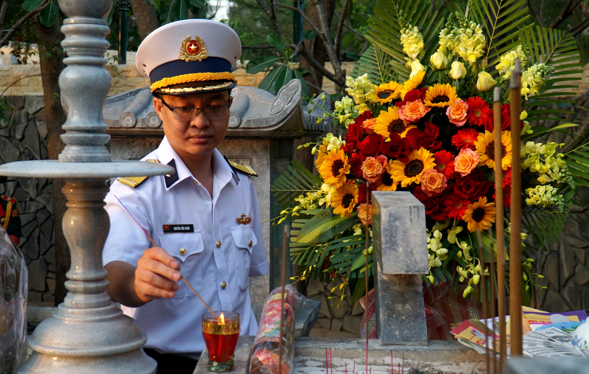 Thiếu tá Nguyễn Tiến Xuân, con của liệt sĩ Nguyễn Mậu Phong, thắp hương tại nơi thờ cha mình. Thiếu tá Xuân đang công tác tại Vùng 4 Hải quân, thường xuyên ra Trường Sa, đi qua nơi bố hi sinh. “Ở đó tôi thường tưởng niệm bố. Mỗi lần như vậy tôi cảm nhận bố đang ở cạnh mình, theo dõi, tiếp thêm sức mạnh cho mình. Hôm nay, tôi rất xúc động khi thấy bố và đồng đội được mọi người quan tâm, tưởng nhớ"- anh Xuân nói. Thiếu tá Nguyễn Tiến Xuân, con của liệt sĩ Nguyễn Mậu Phong, thắp hương tại nơi thờ cha mình. Thiếu tá Xuân đang công tác tại Vùng 4 Hải quân, thường xuyên ra Trường Sa, đi qua nơi bố hi sinh. “Ở đó tôi thường tưởng niệm bố. Mỗi lần như vậy tôi cảm nhận bố đang ở cạnh mình, theo dõi, tiếp thêm sức mạnh cho mình. Hôm nay, tôi rất xúc động khi thấy bố và đồng đội được mọi người quan tâm, tưởng nhớ"- anh Xuân nói.