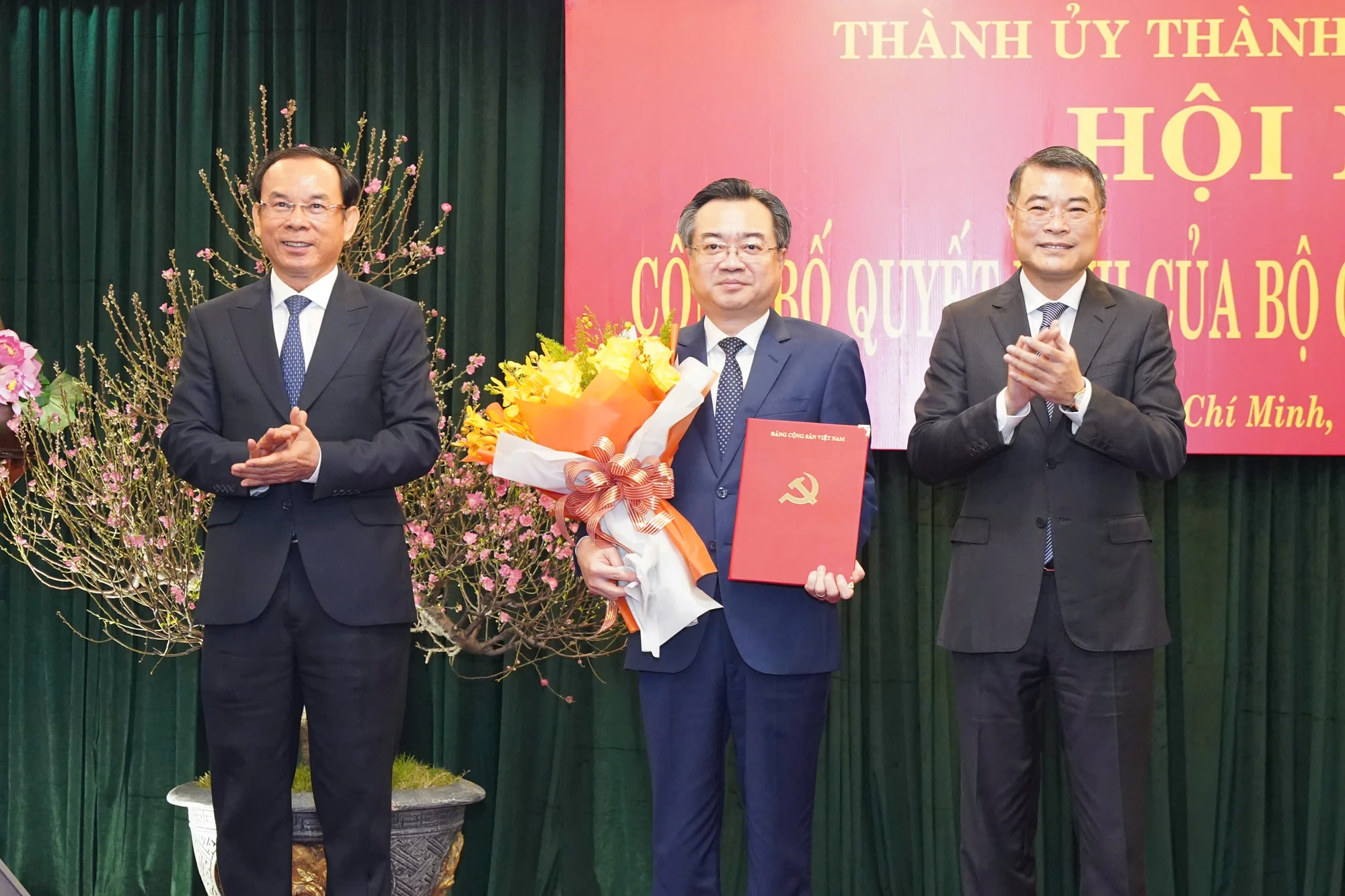 Ông Lê Minh Hưng, Ủy viên Bộ Chính trị, Bí thư Trung ương Đảng, Trưởng ban Tổ chức Trung ương và ông Nguyễn Văn Nên, Ủy viên Bộ Chính trị, Bí thư Thành ủy TP.HCM, trao quyết định, tặng hoa chúc mừng cho tân Phó Bí thư Thường trực Thành ủy TP.HCM Nguyễn Thanh Nghị. Ảnh: THUẬN VĂN