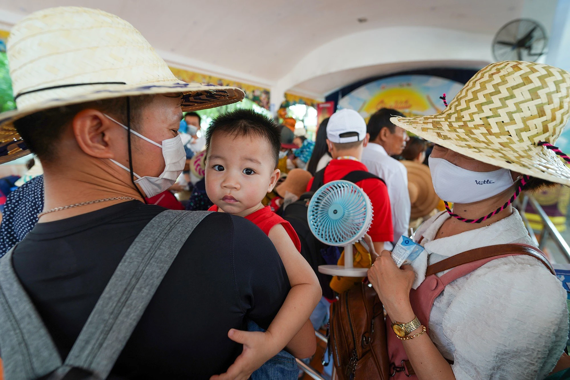 Em nhỏ được cha mẹ trang bị thêm quạt gió mini để tha hồ vui chơi trong ngày thời tiết Sài Gòn có phần oi bức.