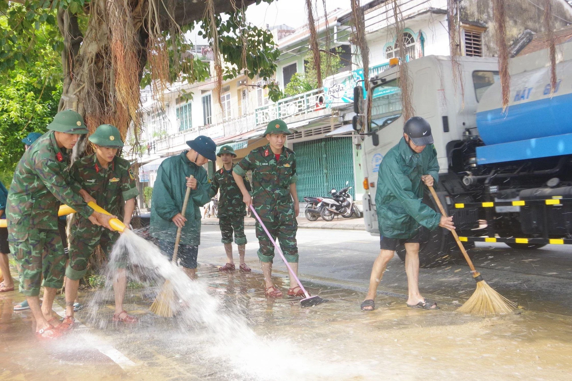 Các cán bộ chiến sĩ tham gia dọn dẹp bùn đất sau lũ.