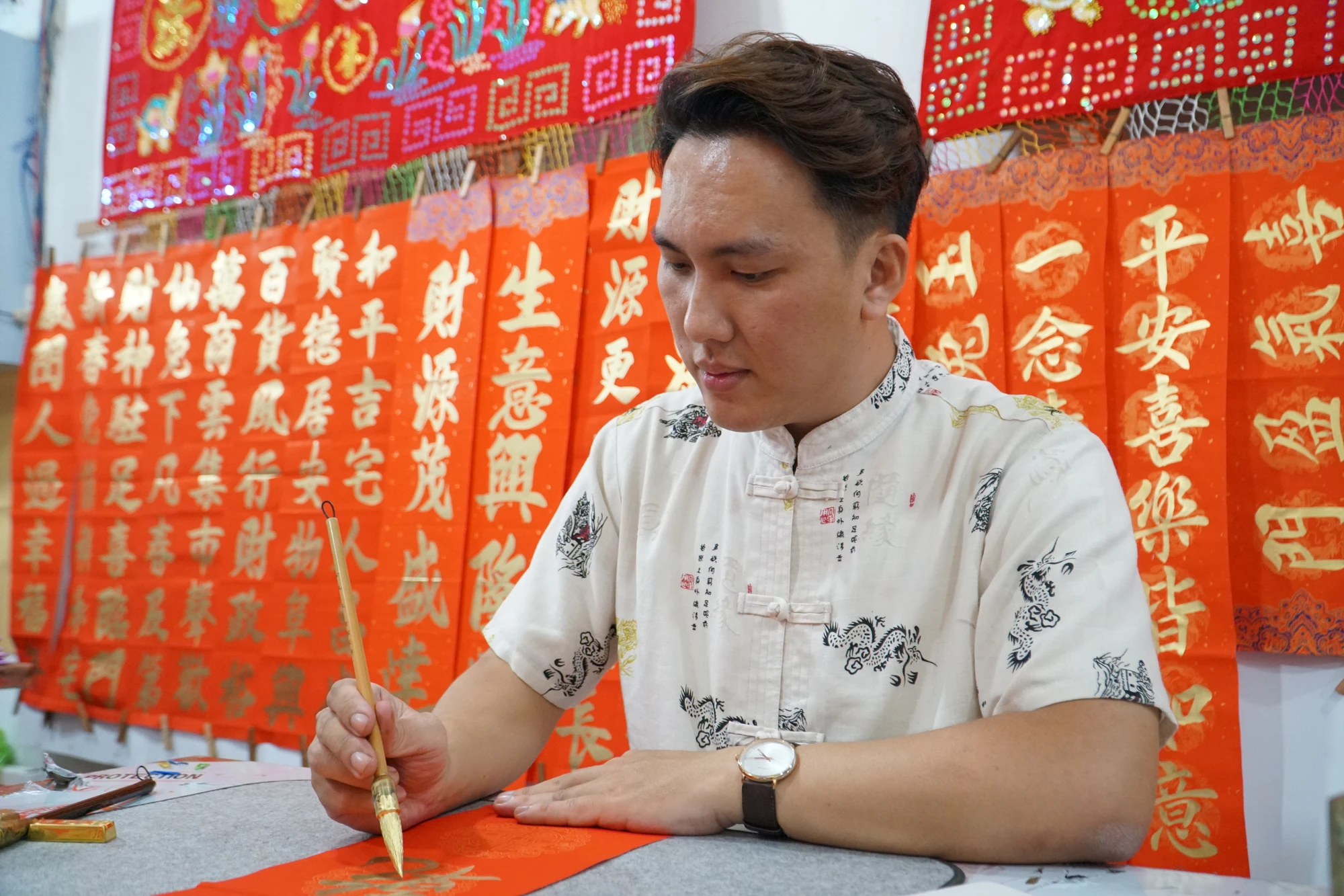 Anh Lương Triều Minh (33 tuổi, em của chị Dũ) cùng thành viên trẻ tuổi trong gia đình đã theo nghề từ năm 15 tuổi. Ngày còn bé, trong những lần tận mắt thấy ba viết chữ, nét bút bay bổng, uốn lượn khiến anh vô cùng hứng thú rồi dần học theo. Anh Lương Triều Minh (33 tuổi, em của chị Dũ) cùng thành viên trẻ tuổi trong gia đình đã theo nghề từ năm 15 tuổi. Ngày còn bé, trong những lần tận mắt thấy ba viết chữ, nét bút bay bổng, uốn lượn khiến anh vô cùng hứng thú rồi dần học theo.