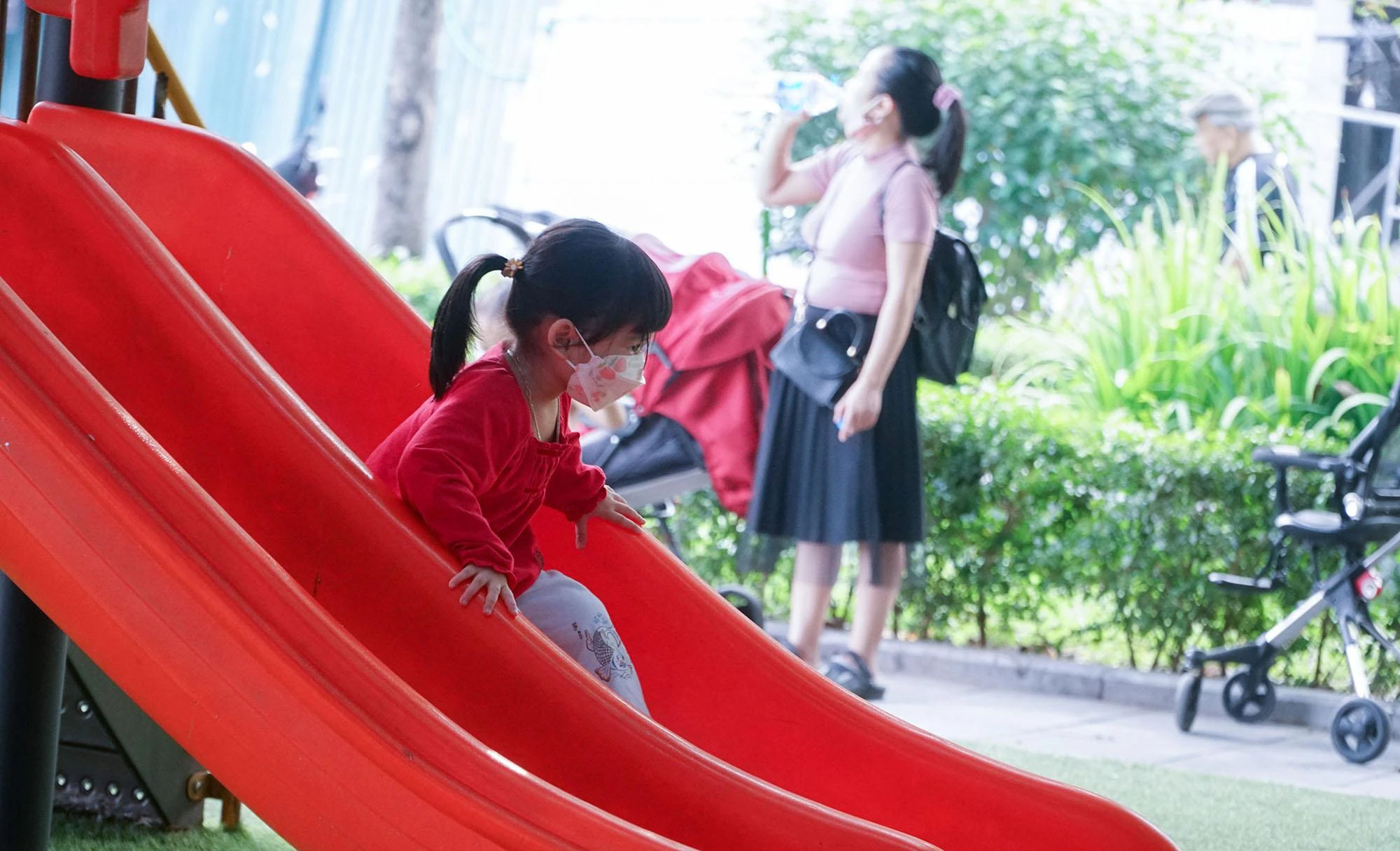 Một em nhỏ được phụ huynh trang bị khẩu trang trong lúc nô đùa tại một sân chơi ven bờ hồ Tây. Một em nhỏ được phụ huynh trang bị khẩu trang trong lúc nô đùa tại một sân chơi ven bờ hồ Tây.