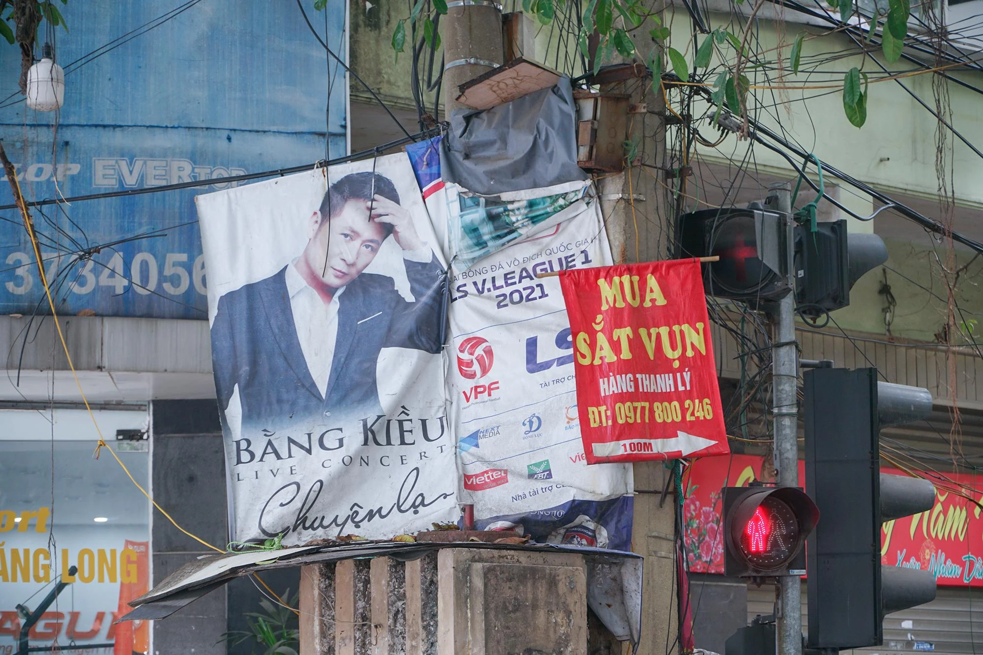 Những tấm băng rôn, banner mới được treo chèn lên các tấm cũ ở một trụ điện gần phố Nguyễn Thái Học, tiềm ẩn nhiều nguy cơ chập cháy... mất mỹ quan.