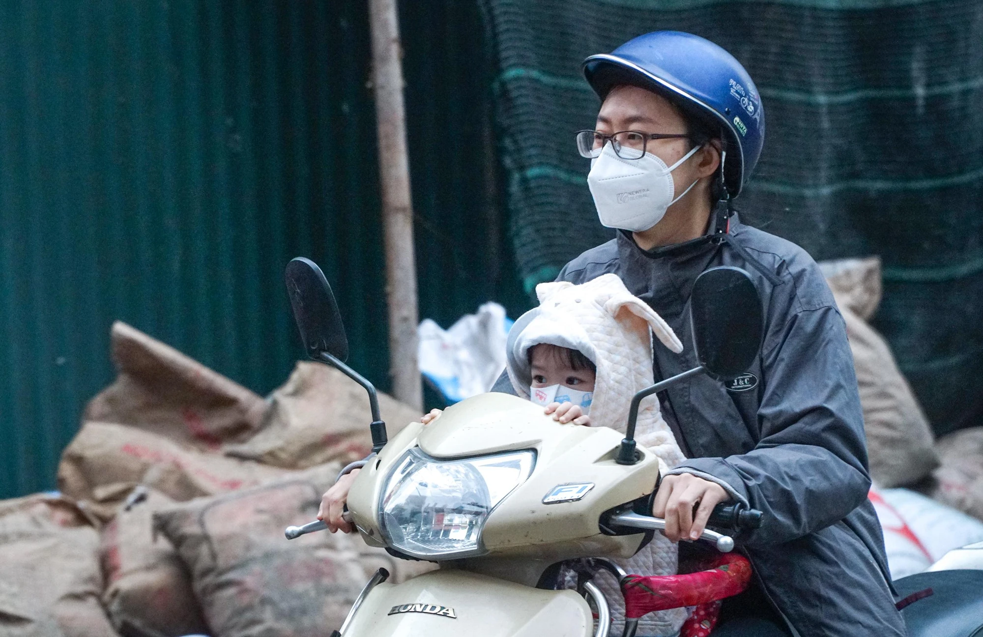 Trên đường Xuân Đỉnh, một em nhỏ được phụ huynh trang bị khẩu trang, áo khoác dày khi tới trường. Trên đường Xuân Đỉnh, một em nhỏ được phụ huynh trang bị khẩu trang, áo khoác dày khi tới trường.