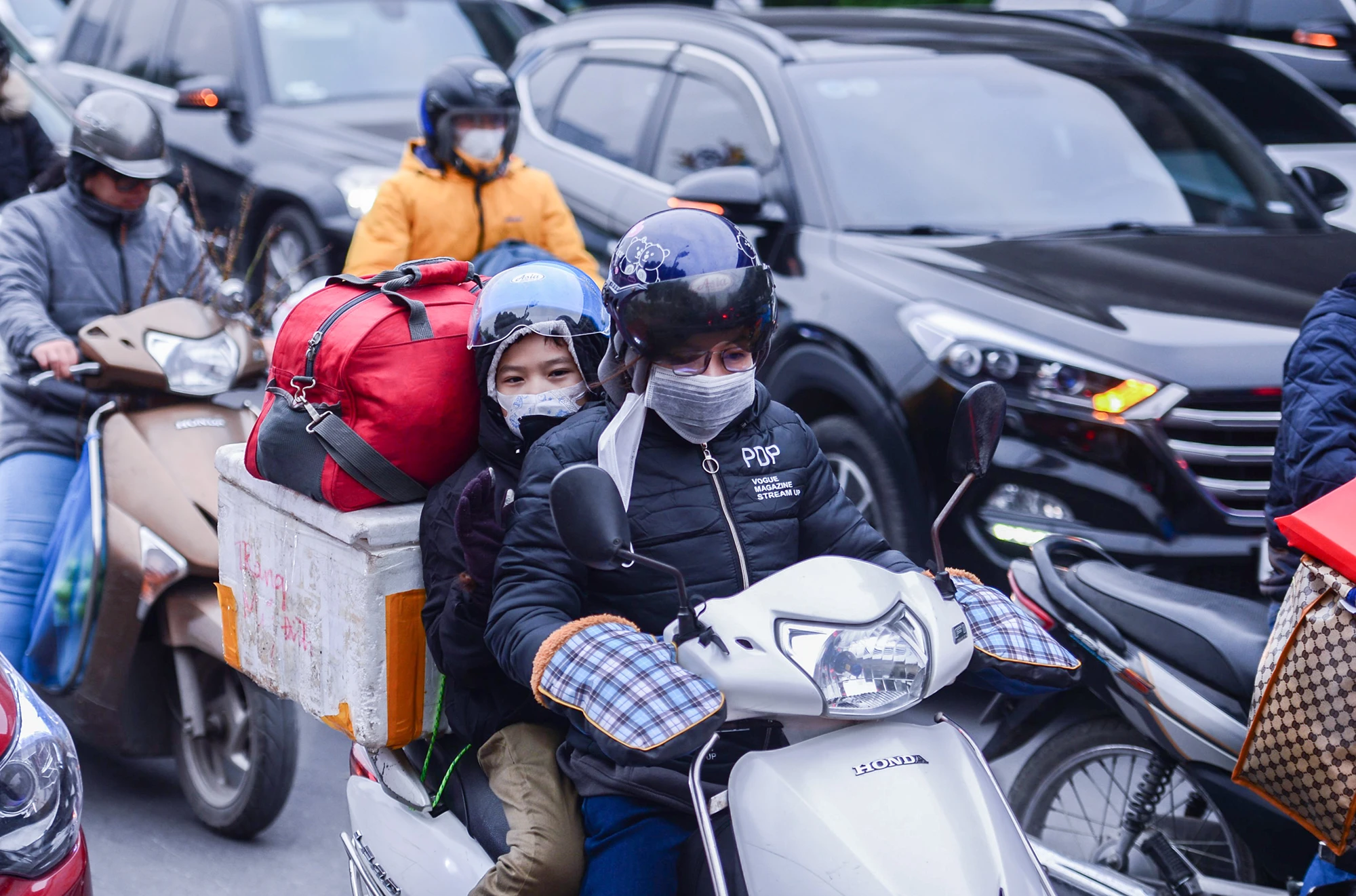 Nhiều người đèo con nhỏ cùng hành lý bằng xe máy để về quê đón Tết Nguyên đán. Nhiều người đèo con nhỏ cùng hành lý bằng xe máy để về quê đón Tết Nguyên đán.