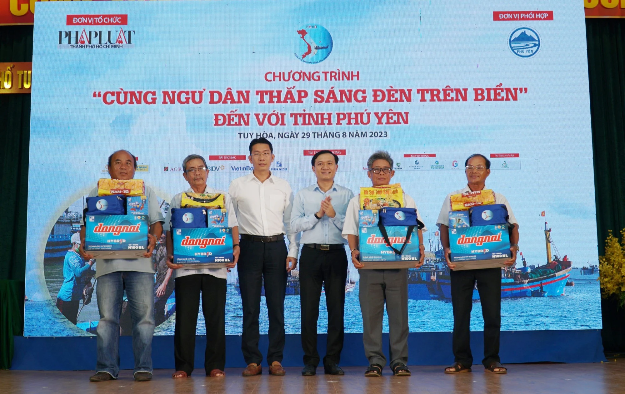 Ông Huỳnh Tấn Lộc (áo trắng), Tổng giám đốc công ty TNHH SKYBUS trao quà cho ngư dân.