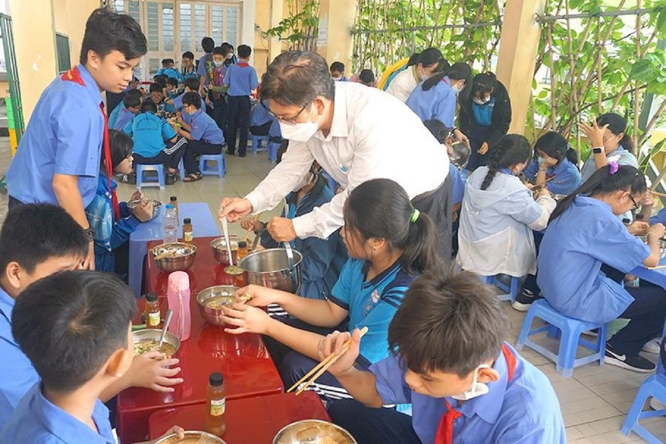 Ông Đinh Phú Cường, Hiệu trưởng Trường THCS Nguyễn Văn Luông, quận 6 tiếp phẩm cho học sinh trong bữa ăn bán trú. Ảnh: NGUYỄN QUYÊN Ông Đinh Phú Cường, Hiệu trưởng Trường THCS Nguyễn Văn Luông, quận 6 tiếp phẩm cho học sinh trong bữa ăn bán trú. Ảnh: NGUYỄN QUYÊN
