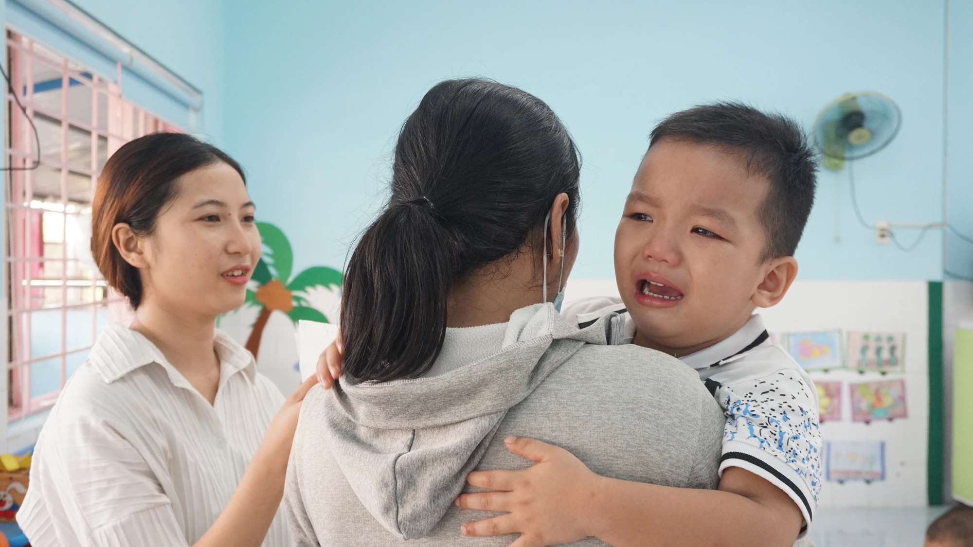 Tuy nhiên, có bé lần đầu tiên đi học nên còn bỡ ngỡ và khóc nhè nên cô và mẹ phải dỗ dành Tuy nhiên, có bé lần đầu tiên đi học nên còn bỡ ngỡ và khóc nhè nên cô và mẹ phải dỗ dành