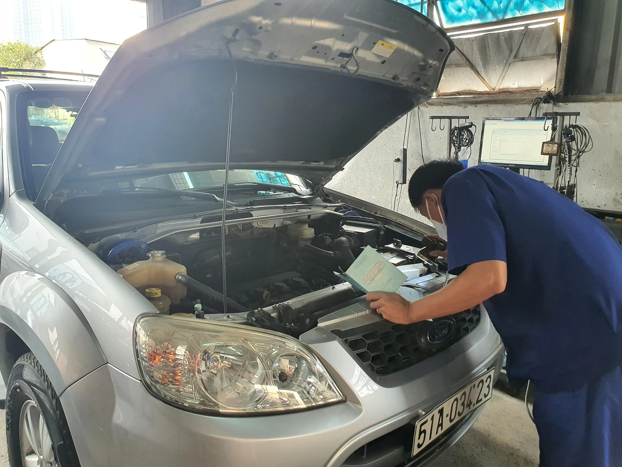 Kiểm định viên đang kiểm tra động cơ xe. Ảnh: THY NHUNG Kiểm định viên đang kiểm tra động cơ xe. Ảnh: THY NHUNG