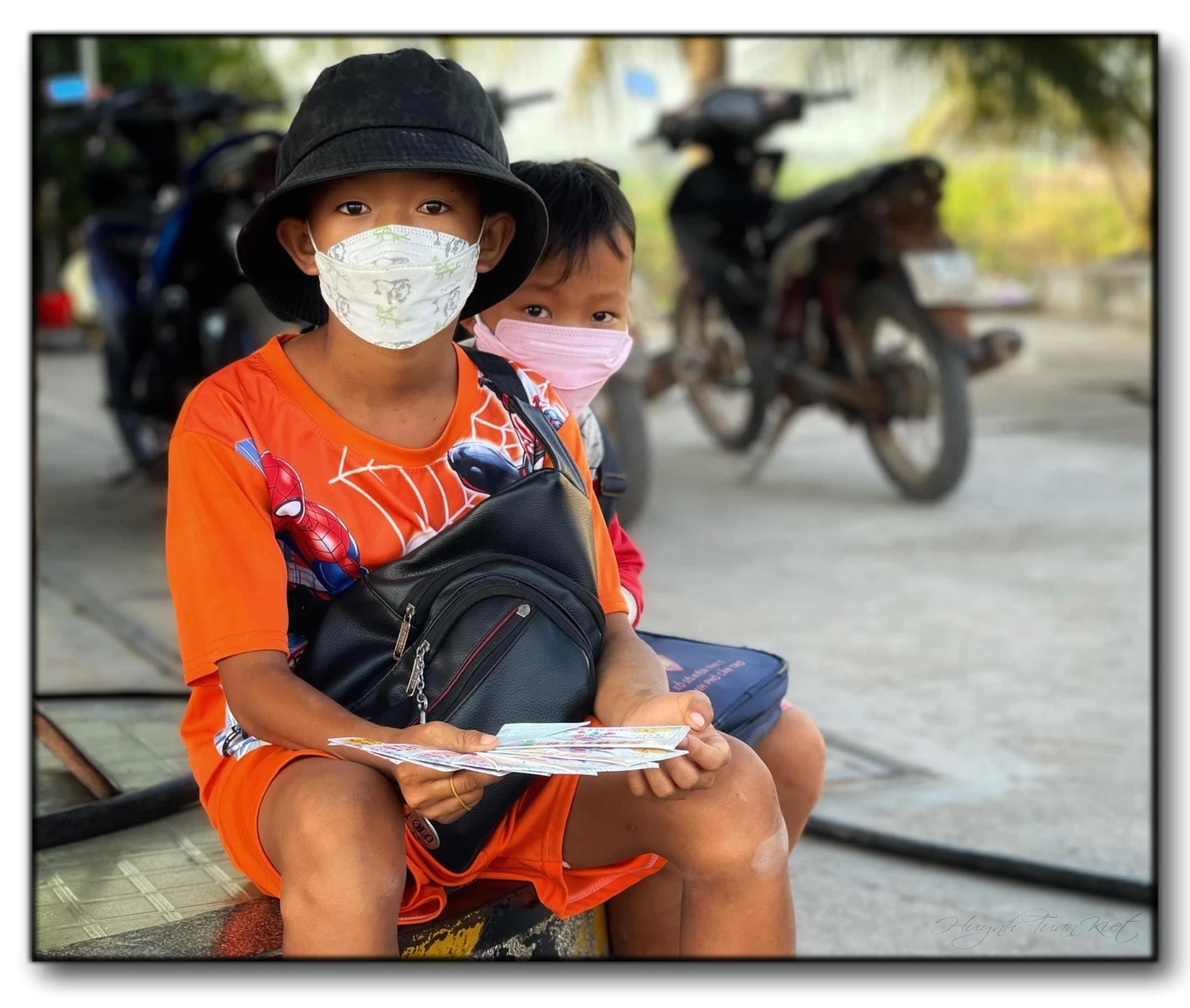 Bức ảnh về 2 em bé bán vé số là con một gia đình di dân Việt Nam-Campuchia. Ảnh: NVCC
