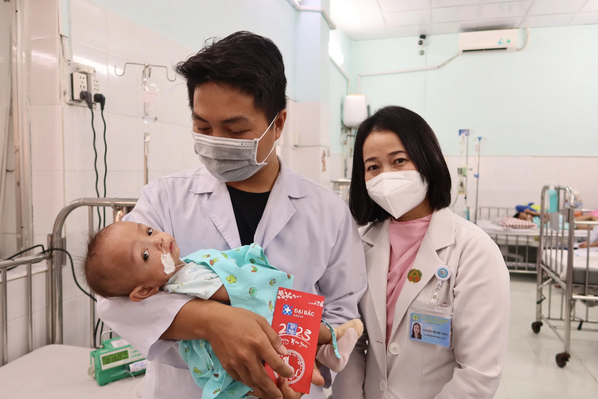 Anh Nguyễn Quốc Trung vui mừng khi hai ba con nhận được lì xì chúc Tết của BV - ảnh: TRẦN MINH