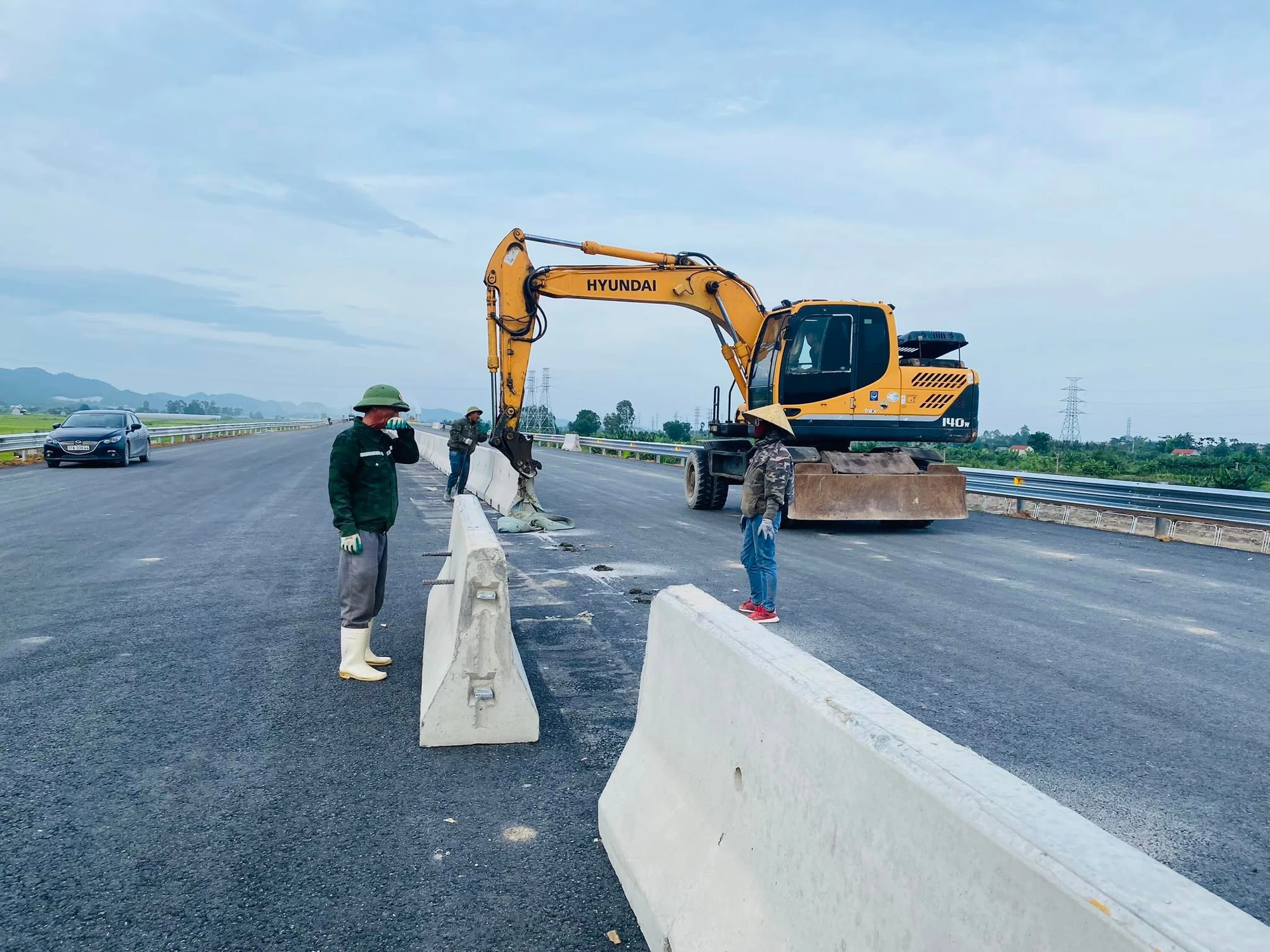 Các công nhân tiến hành lắp dải phân cách. Ảnh: ĐẮC LAM