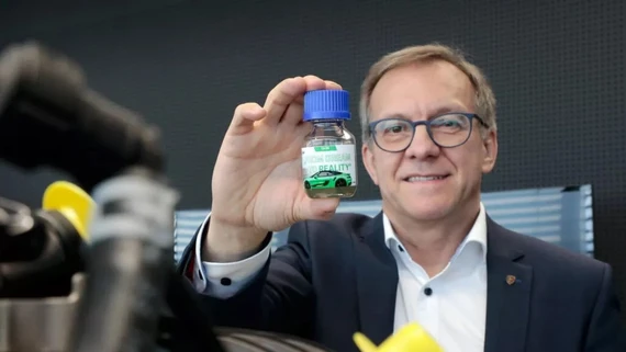 Ông Karl Dums của Porsche với eFuel. Ảnh: Carcoops. Nhien- lieu -dien -tu-cothe-gay-o-nhiem-gap-5-lan-so -voi-xe-dien-1.jpg