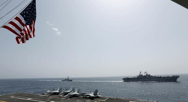 Tàu đổ bộ tấn công USS Kearsarge (phải) và tàu khu trục USS Bainbridge (trái) trang bị tên lửa dẫn đường di chuyển trên biển Ả Rập ngày 17-5. AP đưa hình ảnh được chụp từ tàu sân bay USS Abraham Lincoln.