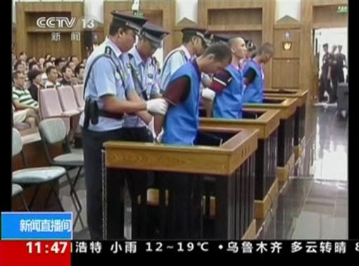 Defendants are escorted by police officers at a courtroom in Kunming City during the trial of four people accused of participating in an attack at a train station in southwestern China, in this still image taken from video September 12, 2014. REUTERS-CCTV via Reuters TV