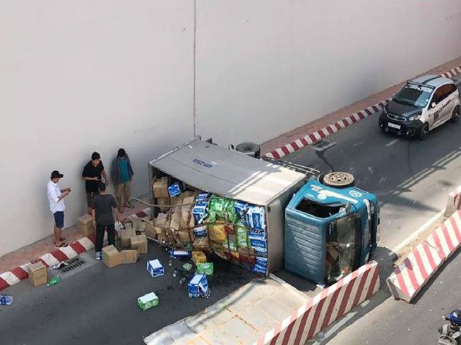 Xe tải lật, người dân giúp tài xế gom hàng hóa