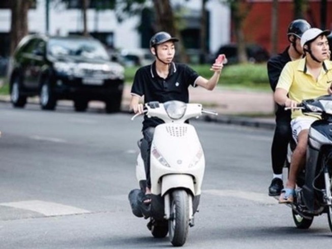 Lái xe máy bằng 1 tay có phạm luật?