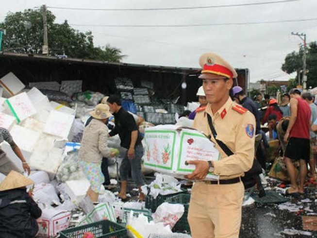 Xe tải lật, CSGT cùng dân giúp gom hàng