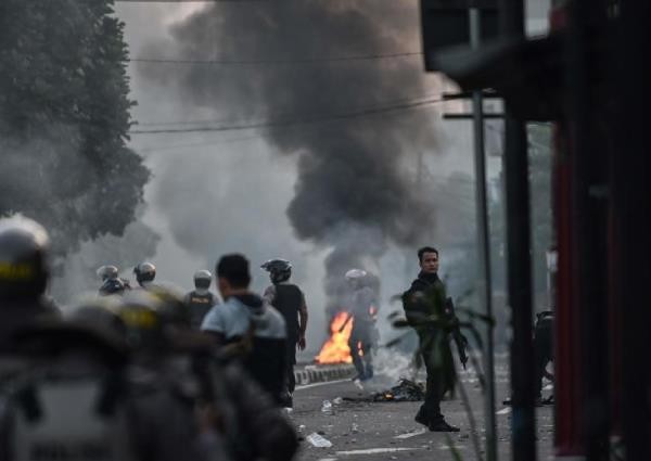 Cảnh sát chống bạo động trong biểu tình ở Indonesia. Ảnh: AFP