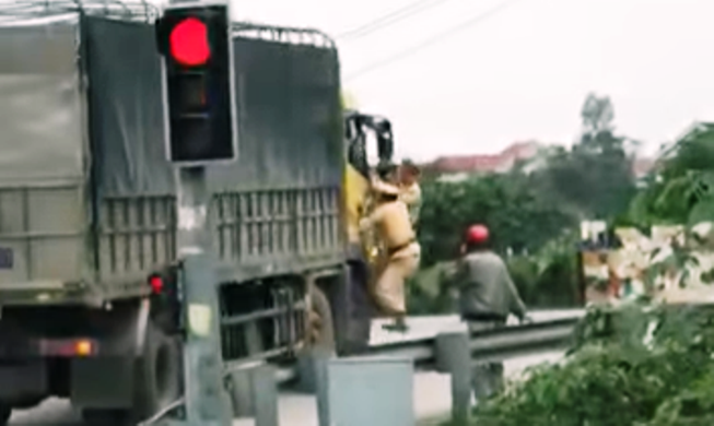 Xôn xao clip 2 CSGT bám cửa xe tải đang chạy