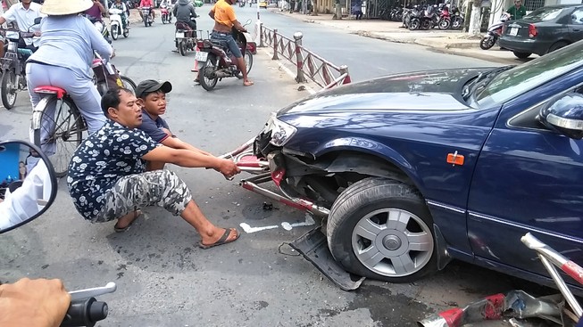xe cán bẹp và dính luôn dải phân cách vào gầm xe (ảnh HÀ HUY)