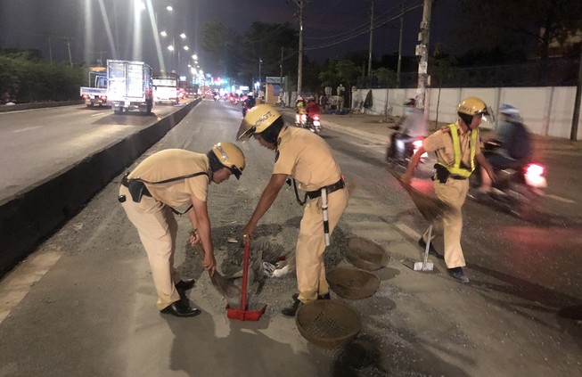 CSGT mang rổ rá, thùng xốp hốt đá sỏi cho dân khỏi trượt té