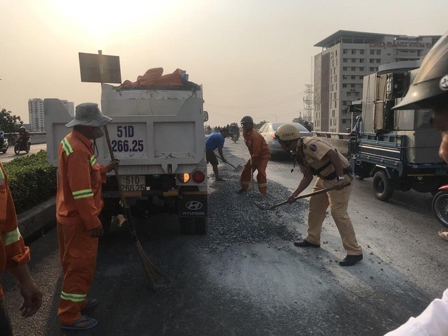 Xe tải vô danh thả đá sỏi tràn cầu vượt Quang Trung