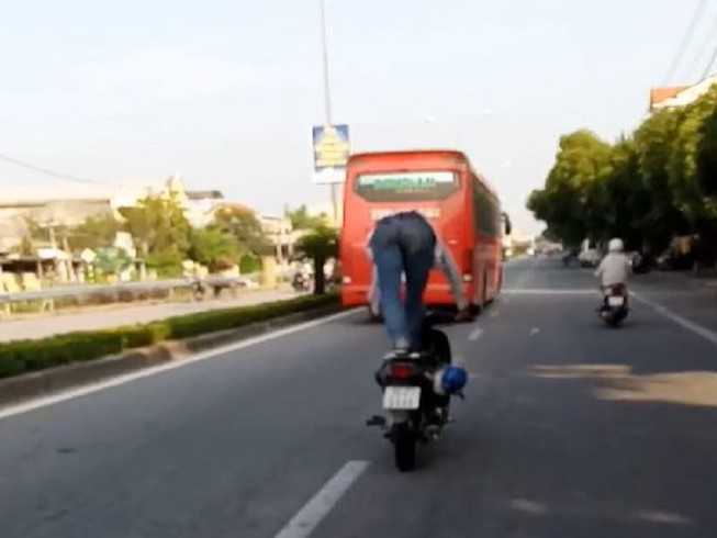 Người đứng trên yên xe máy khi chạy xe bị phạt tiền