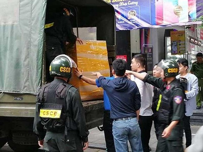 Cảnh sát thu giữ nhiều tang vật sau khi khám xét cơ sở của Nhật Cường Mobile. Ảnh: T.PHAN