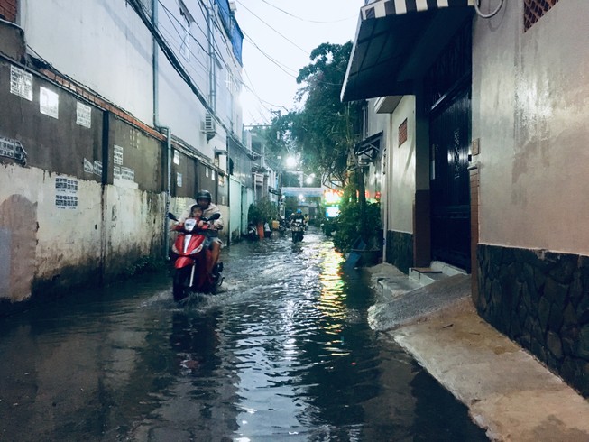 Dân TP.HCM bì bõm lội nước trong cơn mưa chiều tầm tã