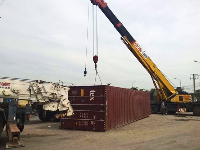 Thùng container 40 feet văng ra đường khi xe ôm cua