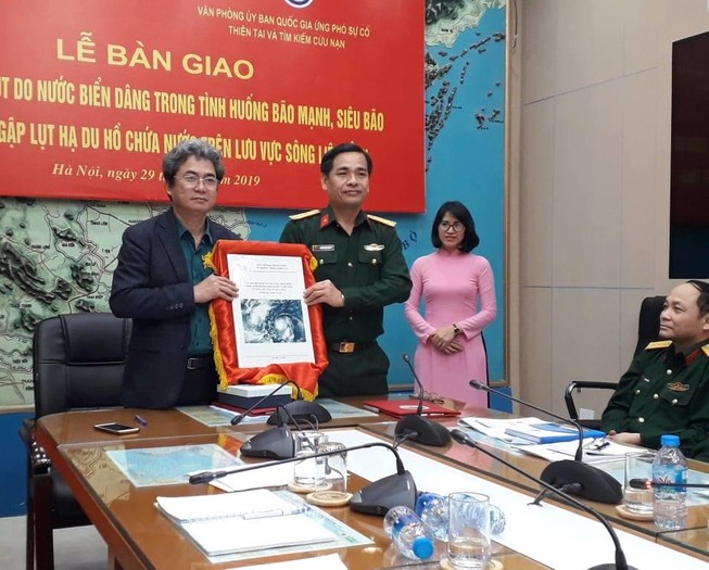 Ông Vũ Xuân Thành, Phó Tổng cục trưởng Tổng cục Phòng chống thiên tai bàn giao bản đồ ngập lụt cho Ủy ban quốc gia Ứng phó sự cố thiên tai và Tìm kiếm cứu nạn.