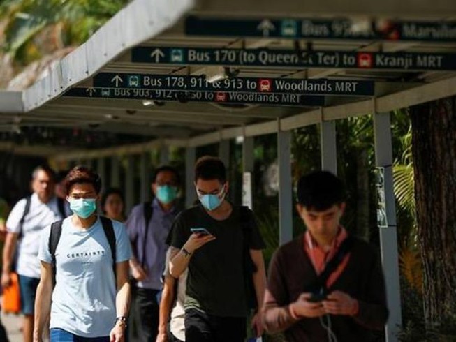 Người Singapore đeo khẩu trang ở khu vực Johor gần biên giới với Malaysia. Ảnh: REUTERS
