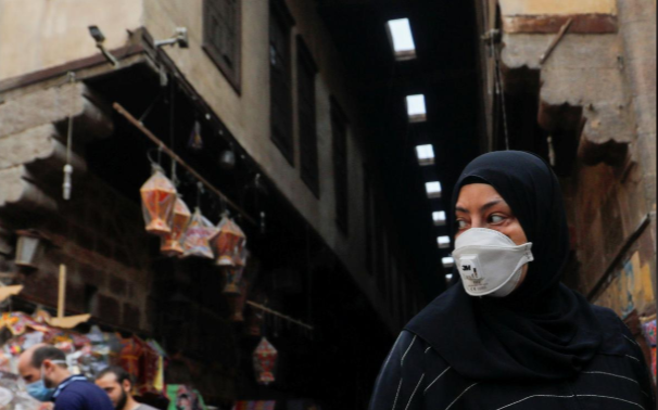 Một phụ nữ Ai Cập đeo khẩu trang, đi mua sắm tại một khu phố cổ ở thủ đô Cairo, Ai Cập. Ảnh: REUTERS