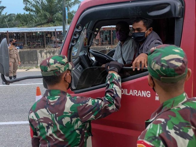 Binh sĩ kiểm tra việc chấp hành hạn chế đi lại trên một đường cao tốc ở TP Pekanbaru (Indonesia) ngày 22-4. Ảnh: GETTY IMAGES