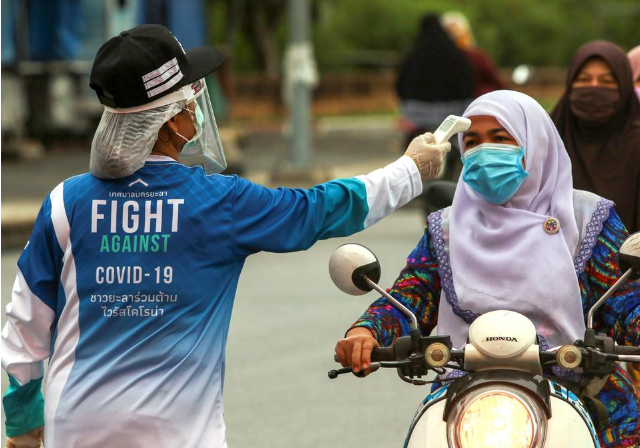 Một phụ nữ được đo nhiệt độ tại một điểm kiểm soát ở tỉnh Yala, Thái Lan. Ảnh: REUTERS