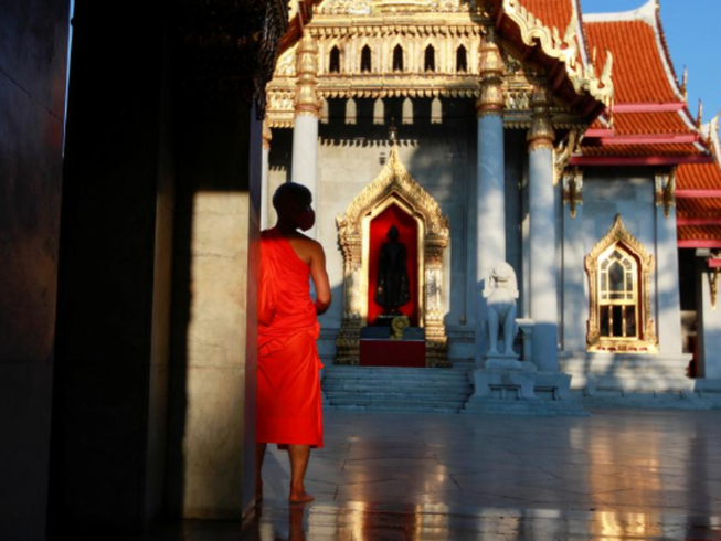 Một thầy tu mang khẩu trang tại một ngôi chùa vắng vẻ do dịch COVID-19 ở Bangkok (Thái Lan). Ảnh: REUTERS