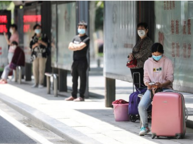 Người dân Vũ Hán đang chờ xe buýt. Ảnh: AFP