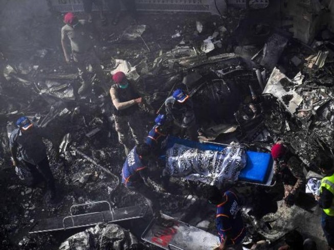 Đội cứu hộ đưa thi thể các nạn nhân ra khỏi hiện trường tai nạn. Ảnh: AFP