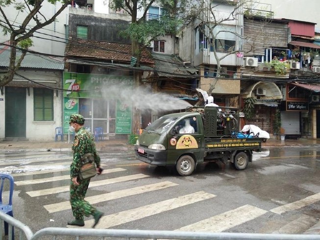 Lực lượng quân đội đang phun thuốc khử trùng khu vực phố Trúc Bạch. Ảnh: VIẾT LONG